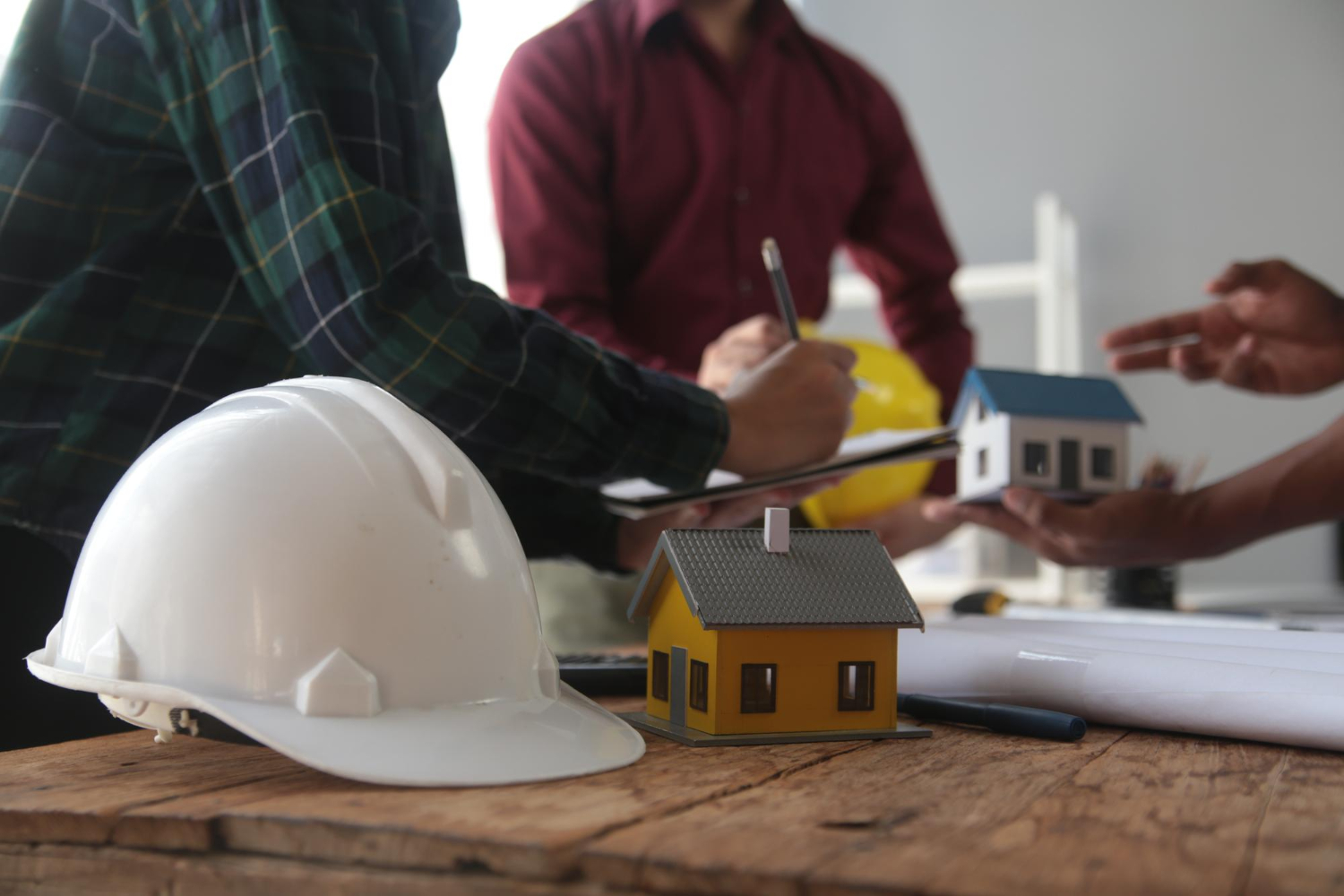 Les ingénieurs consultent l'équipe pour concevoir une structure architecturale pour les clients avec des plans et des modèles de bâtiment